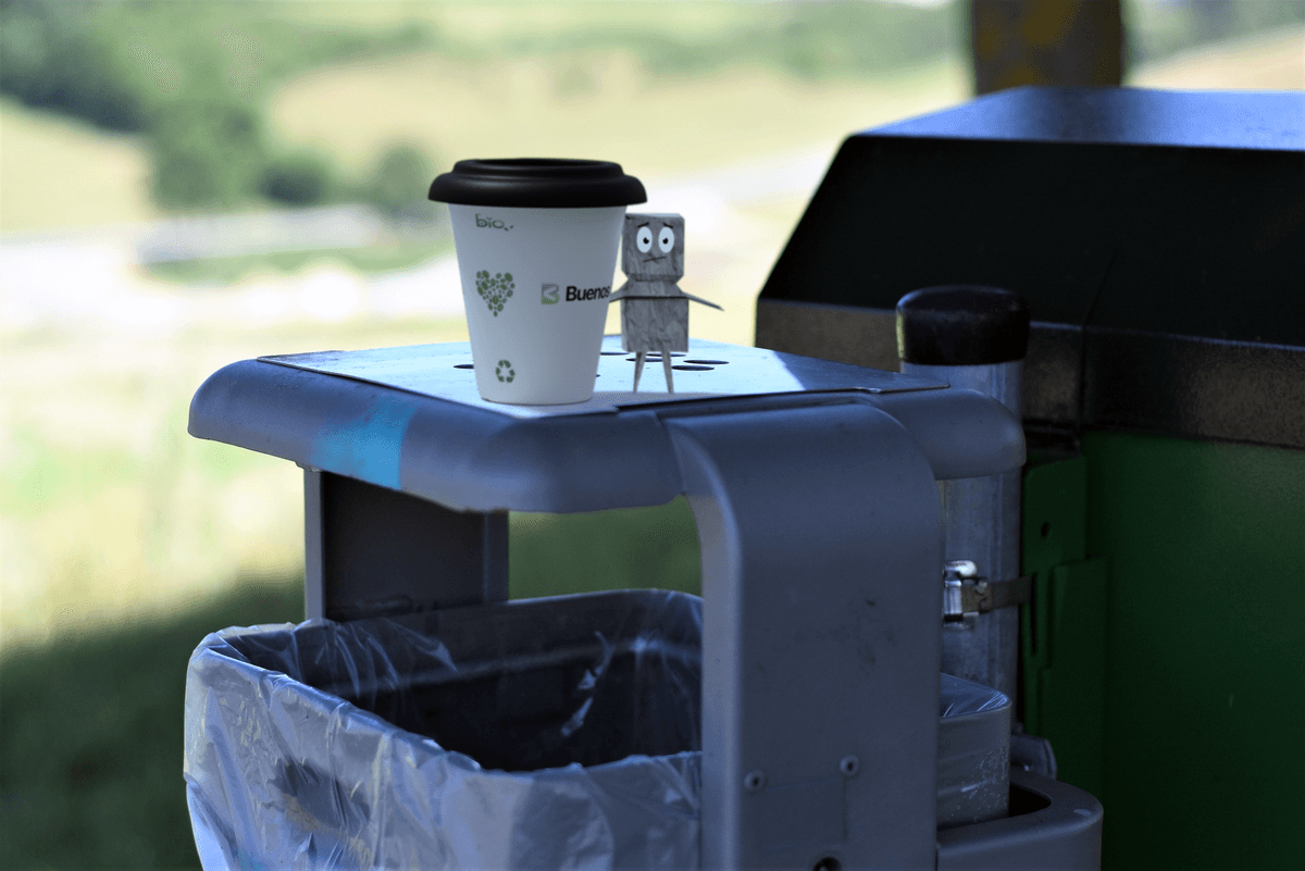 Cup of coffee on top of trash can